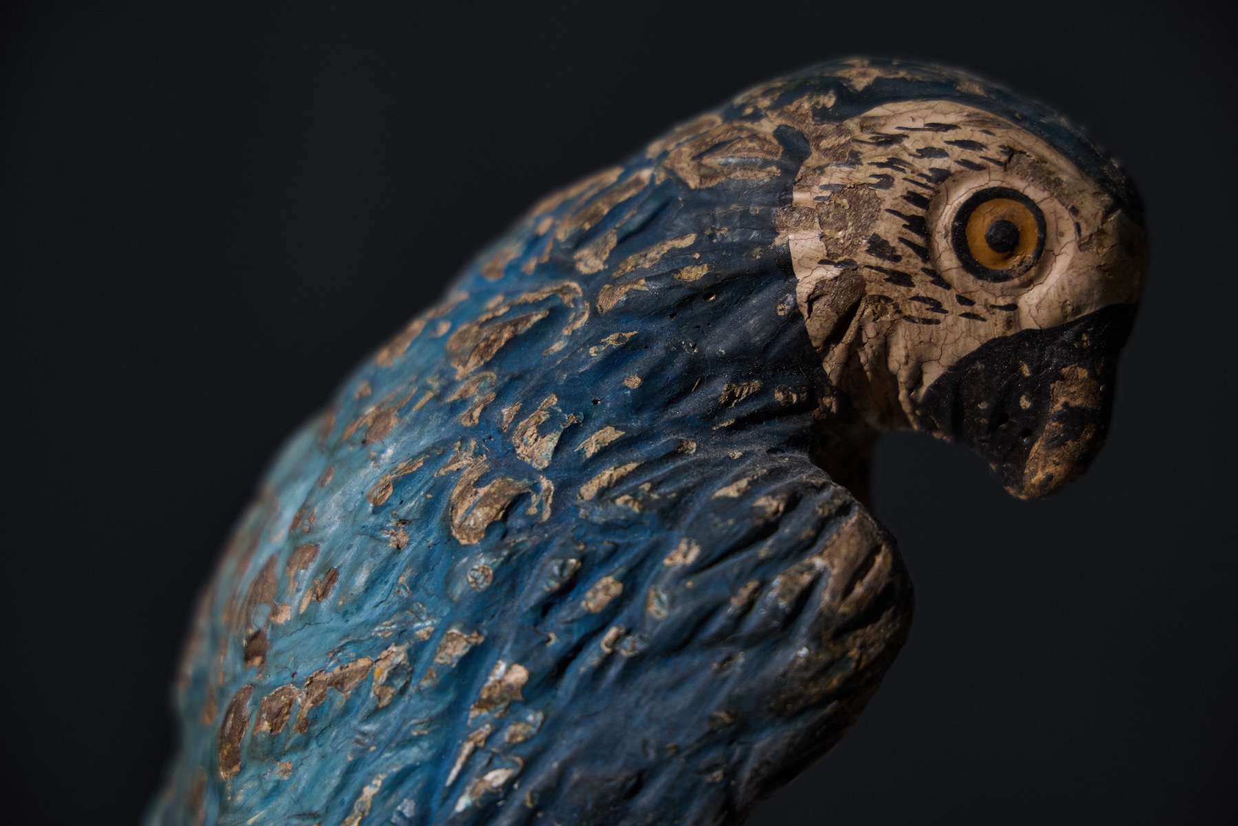 Expressive carved parrot statues with aged patina
