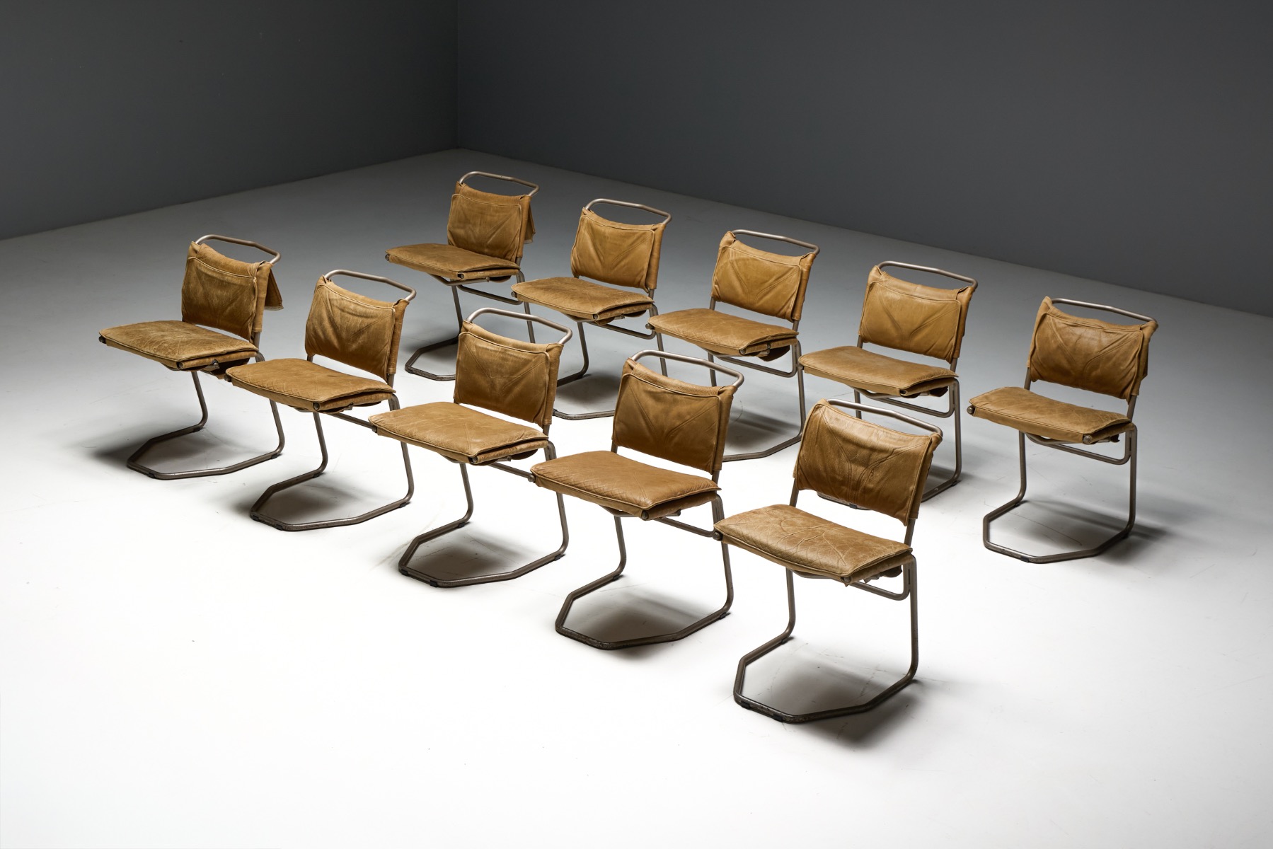 Sculptural dining chairs with steel frame and leather upholstery