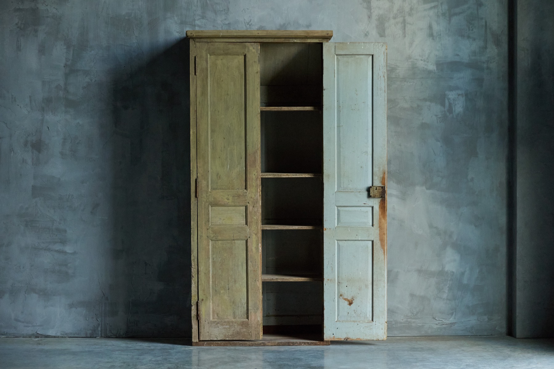 Antique primitive green cupboard in aged wood
