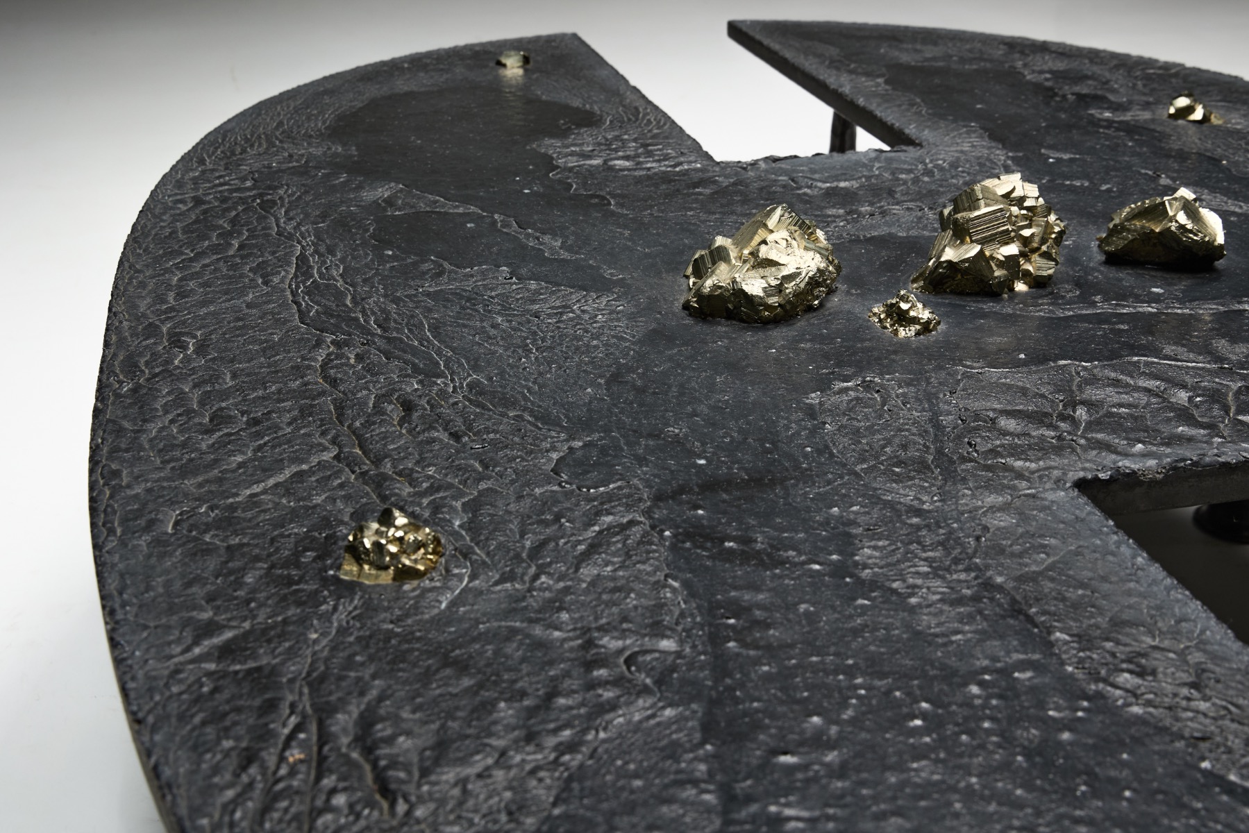 Iron coffee table with mineral inclusions in brutalist design language
