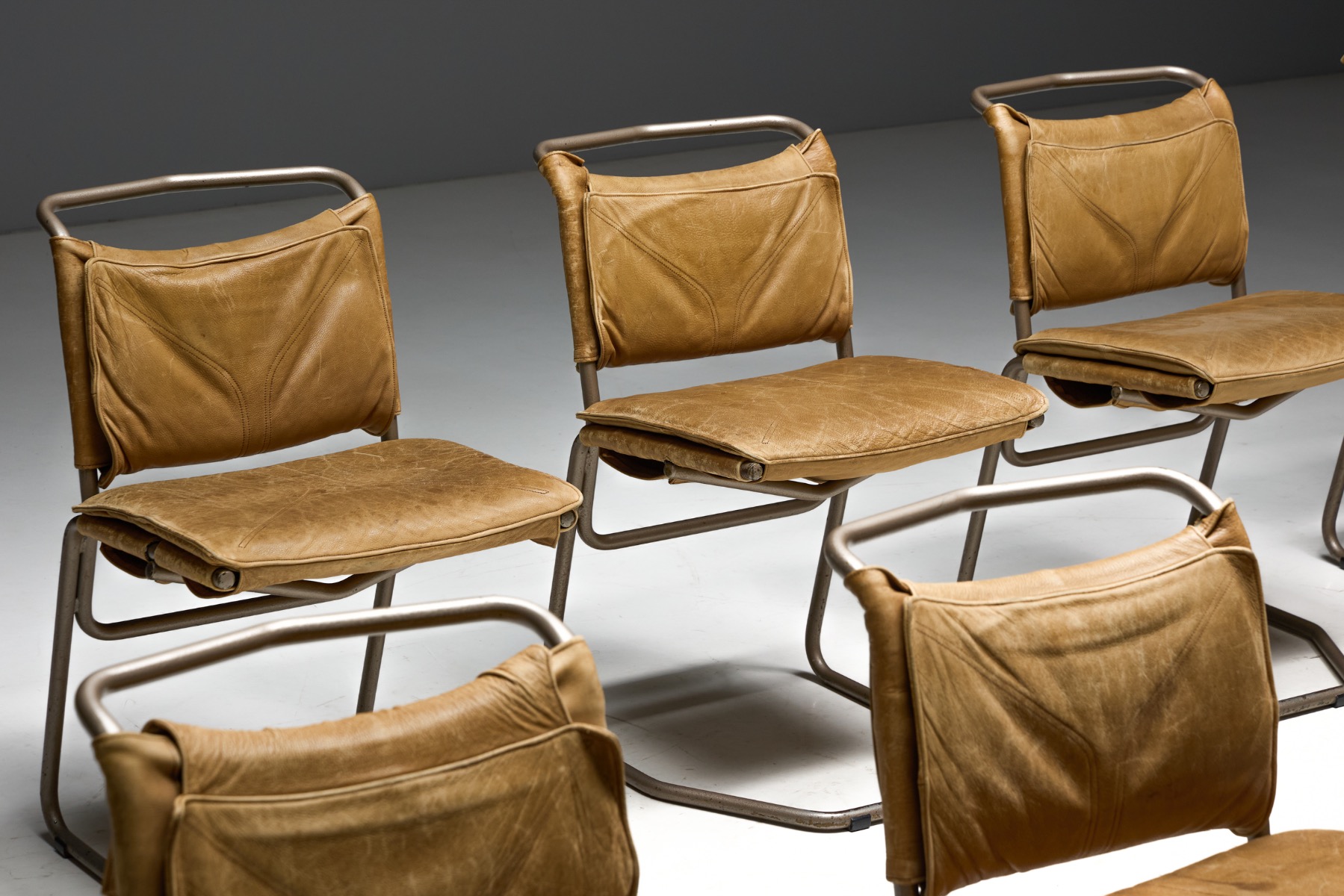 Steel base dining chairs with leather seating surfaces