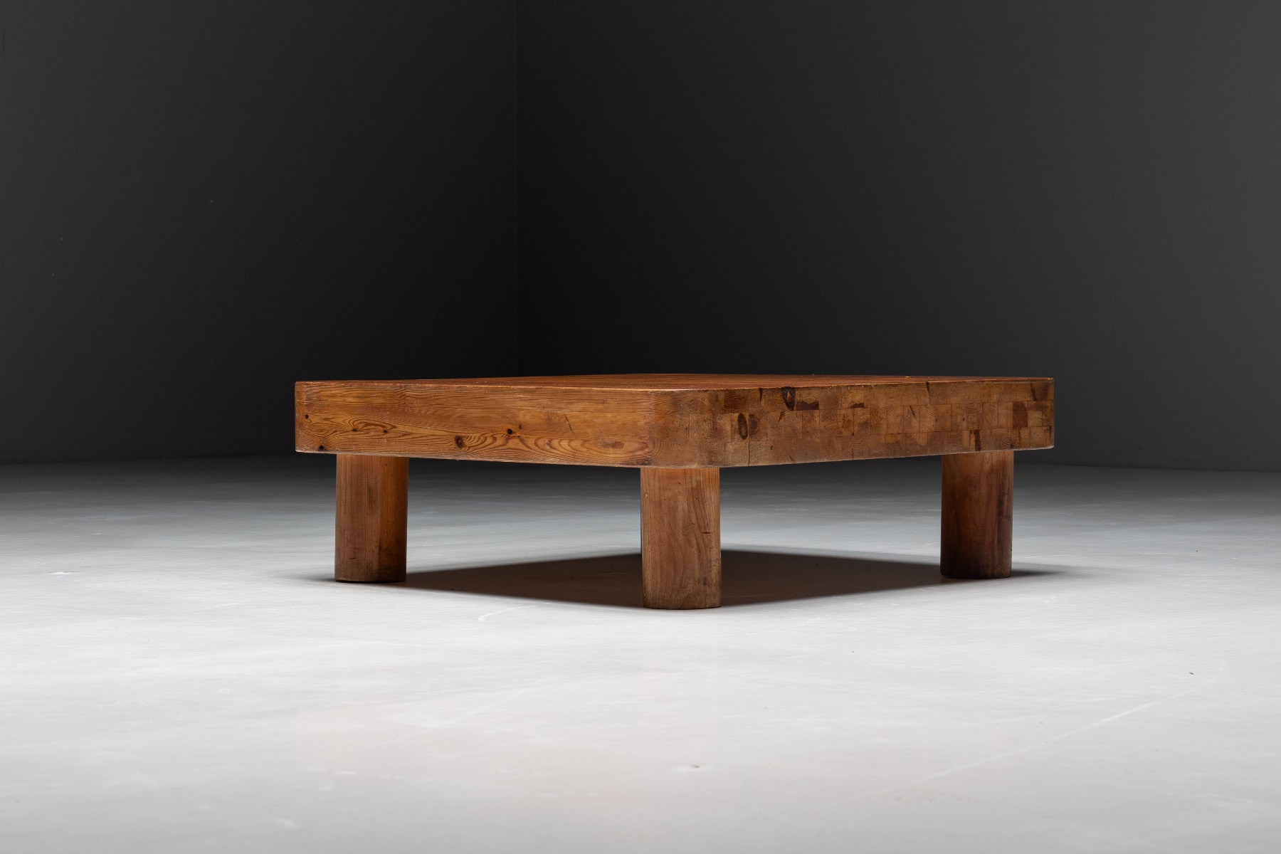 Monolithic brutalist pine coffee table with strong architectural lines