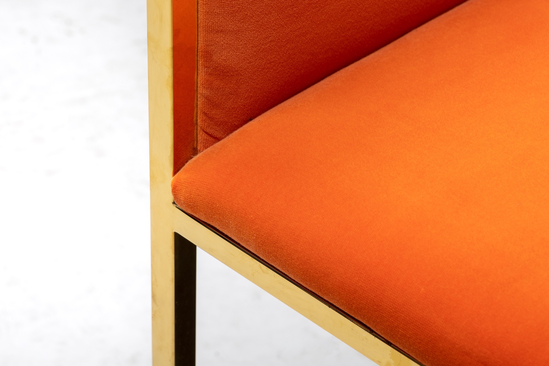 Designer dining armchairs combining brass and orange velvet