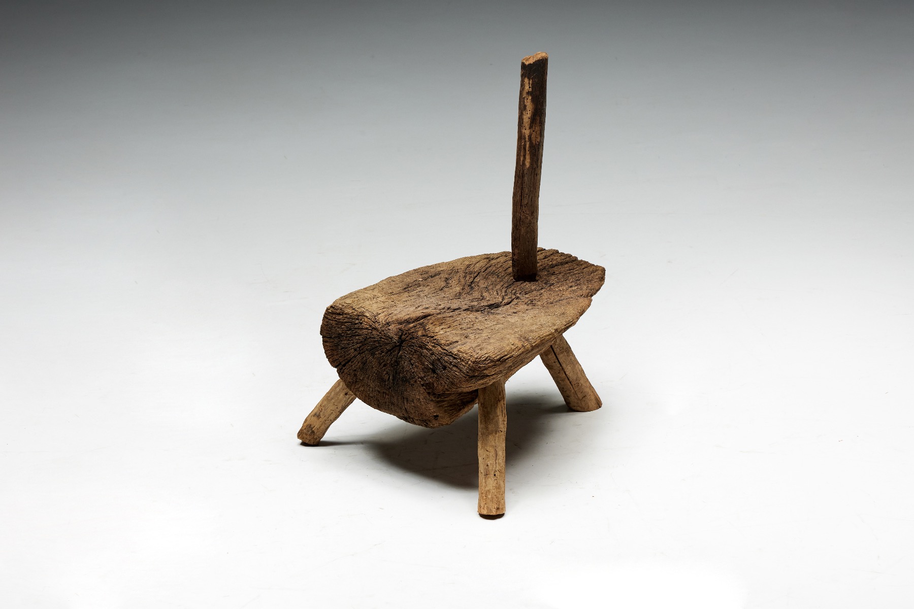 Antique monoxylite tripod chair in folk style