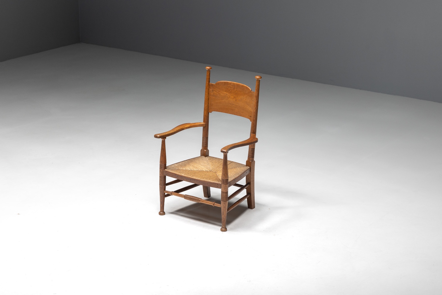 Antique oak armchair with straw seat in rustic style