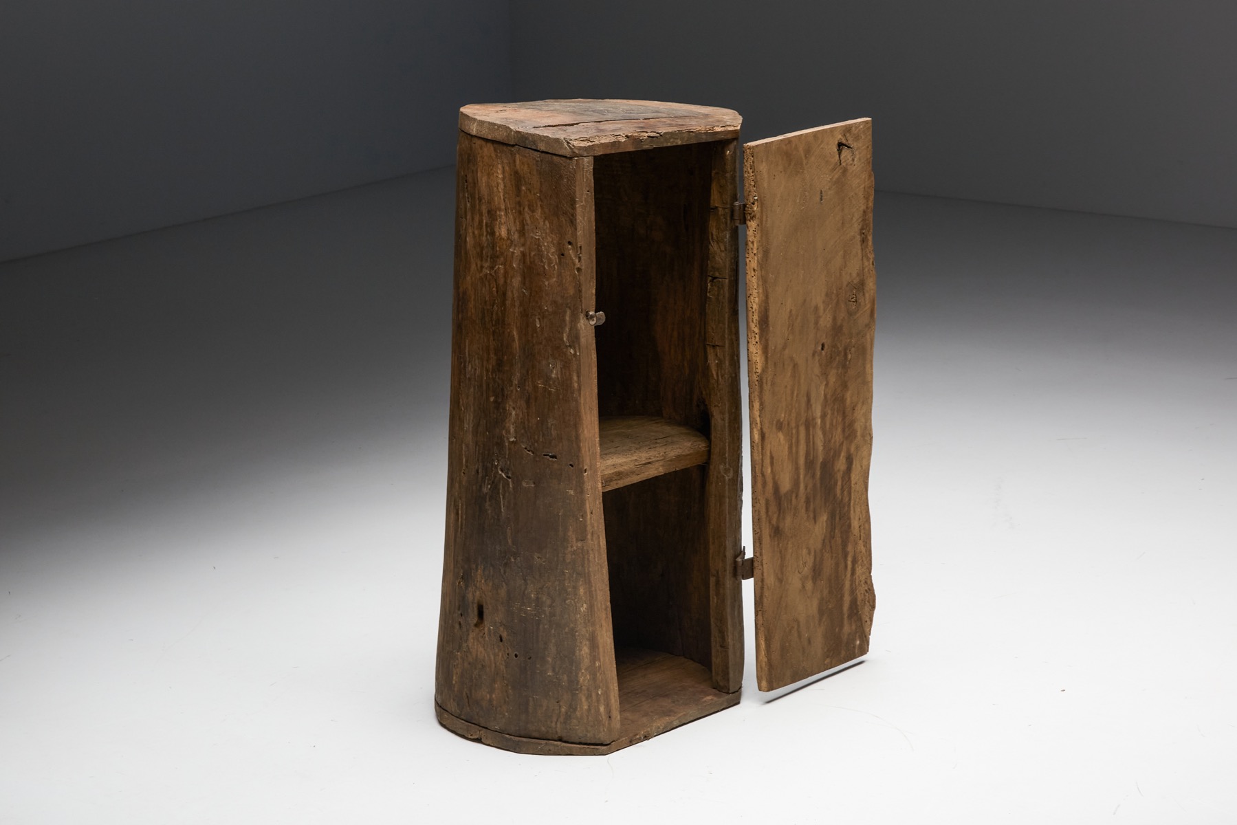 Primitive monoxylite wooden cabinet in design