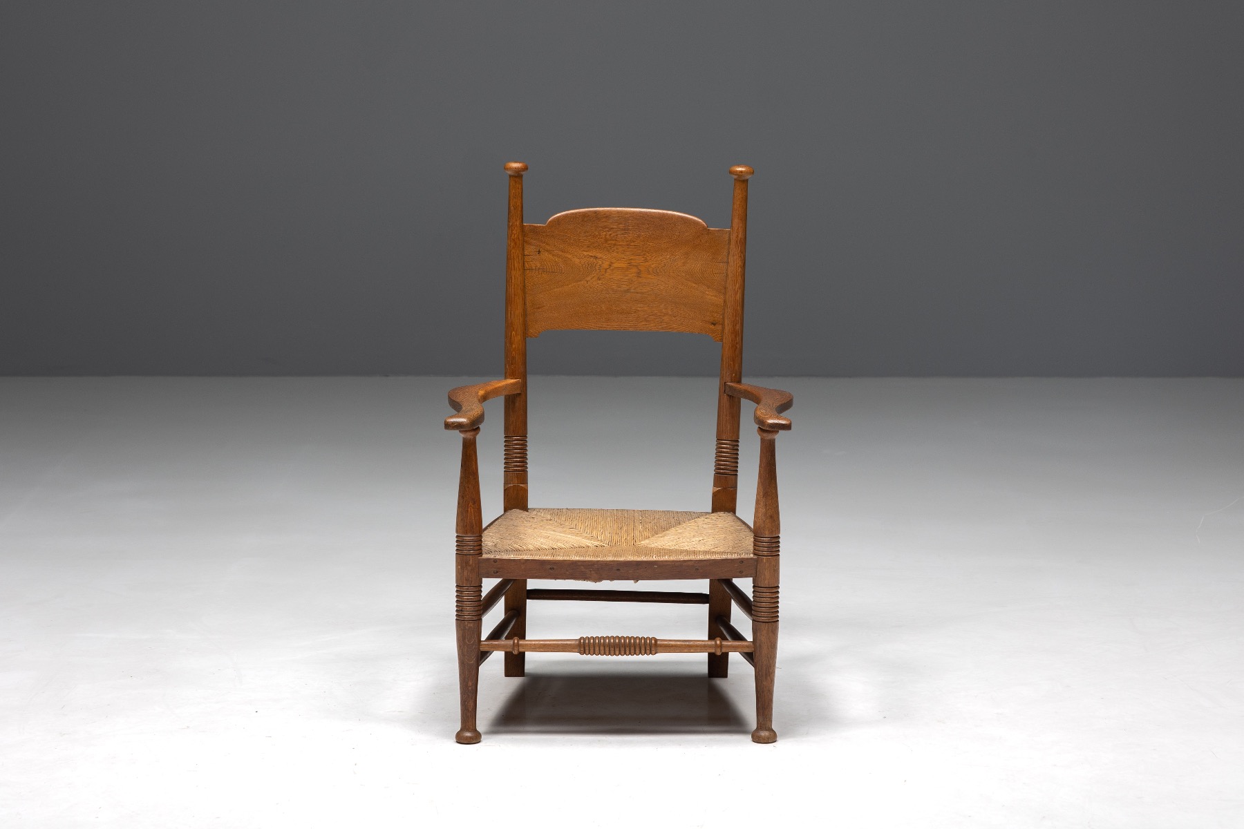 Primitive oak wood armchair with woven straw seat