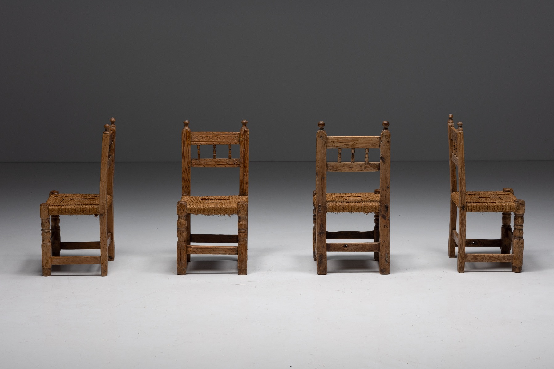 Primitive wooden dining chairs with woven straw seats