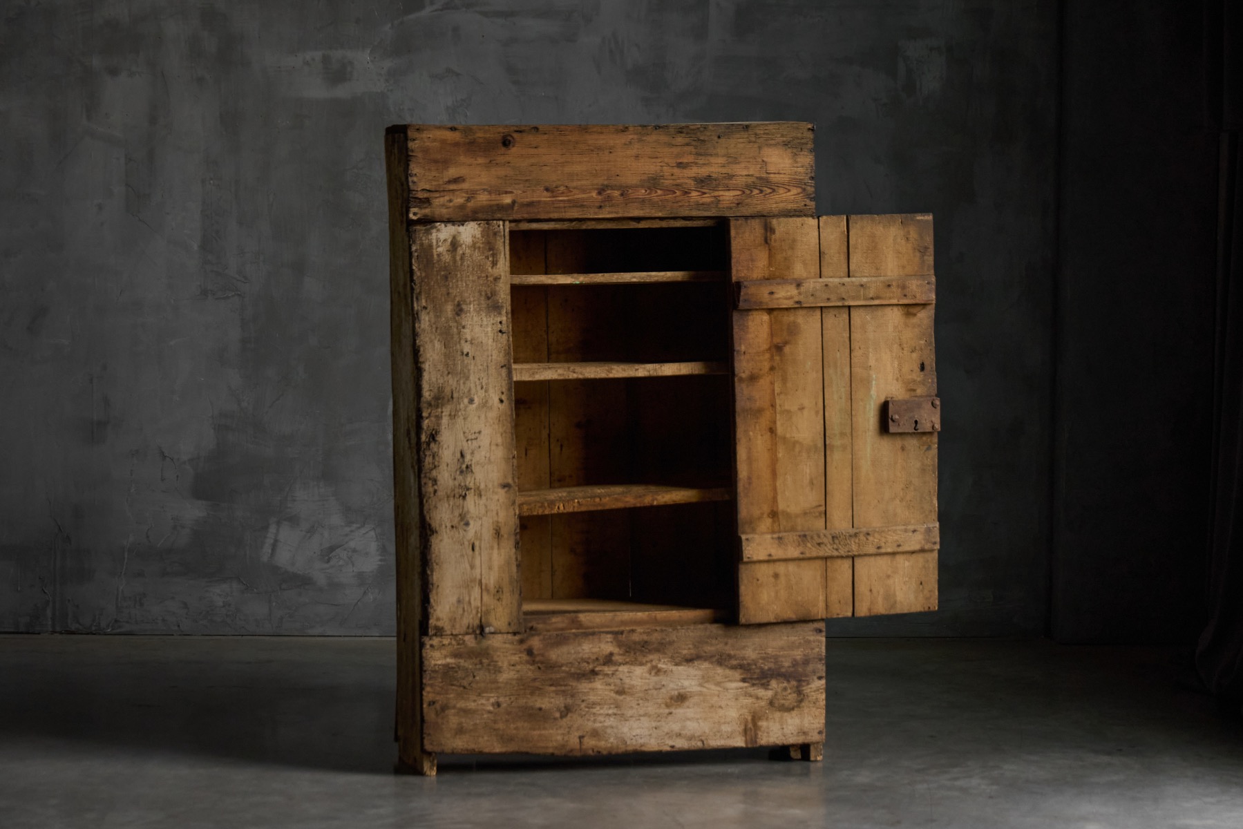 Antique rustic wooden cabinet from 19th century France with simple iron hardware