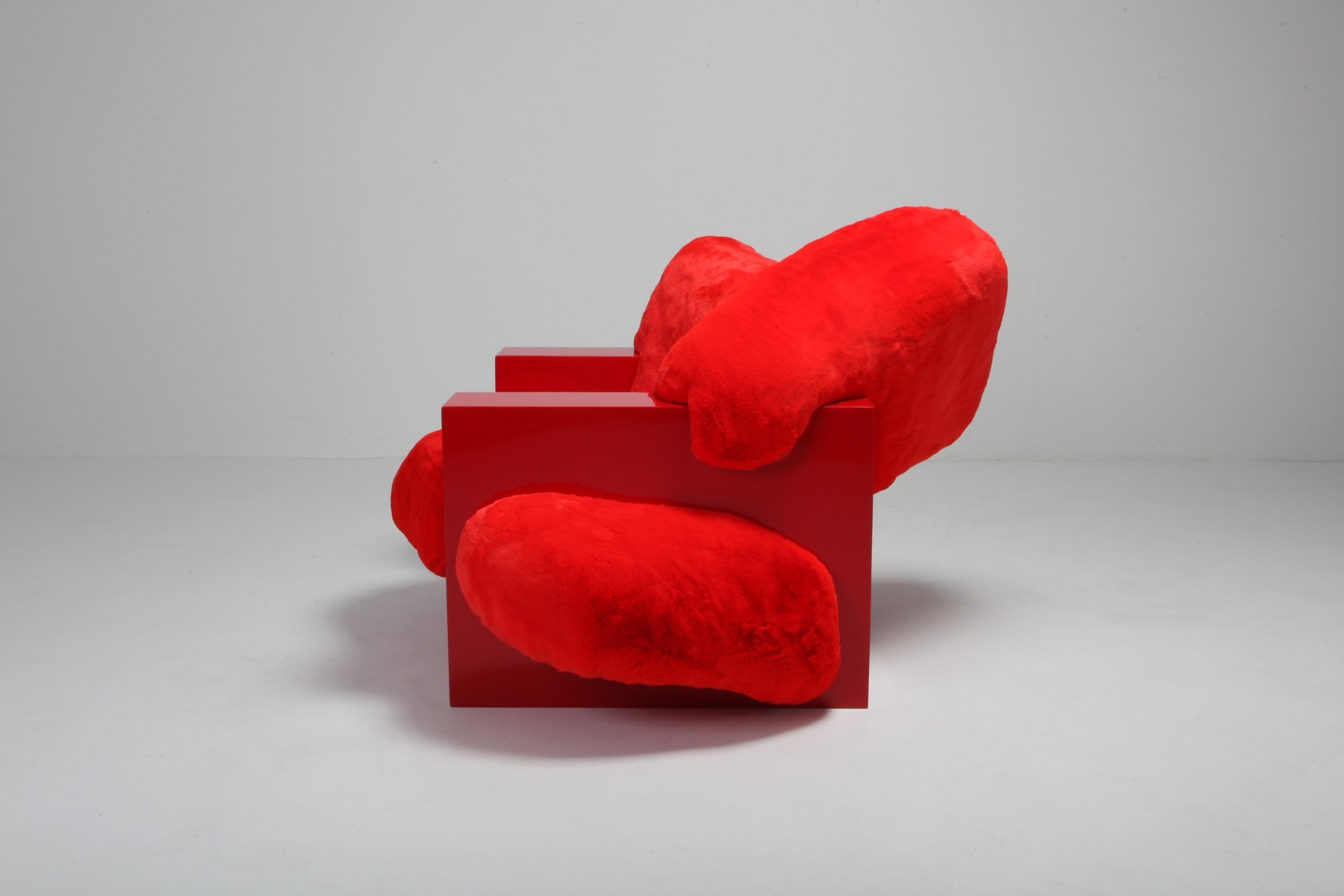 Modern lounge chair in red lacquer and faux fur design