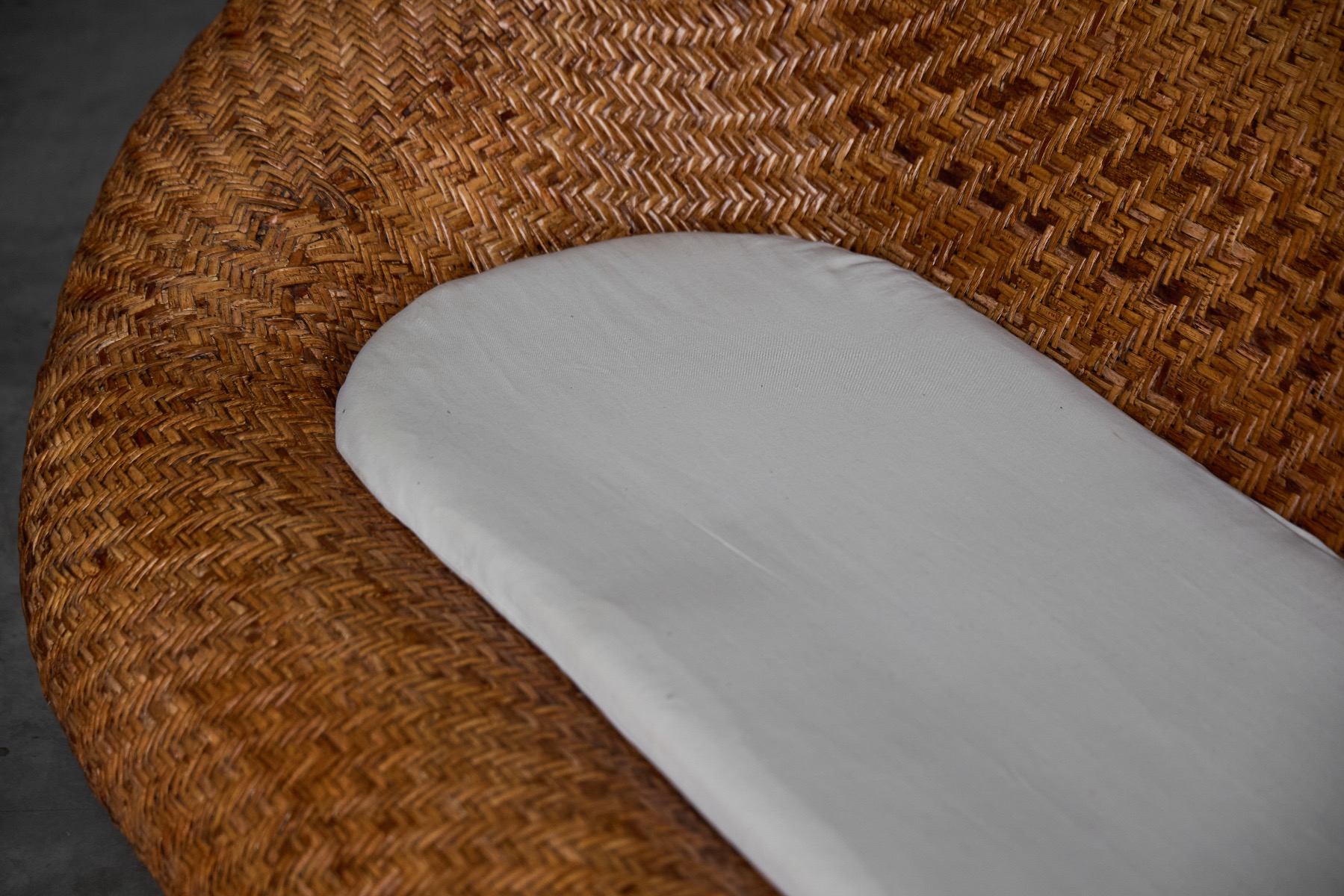 Woven wicker sofa reflecting 1970s design aesthetics