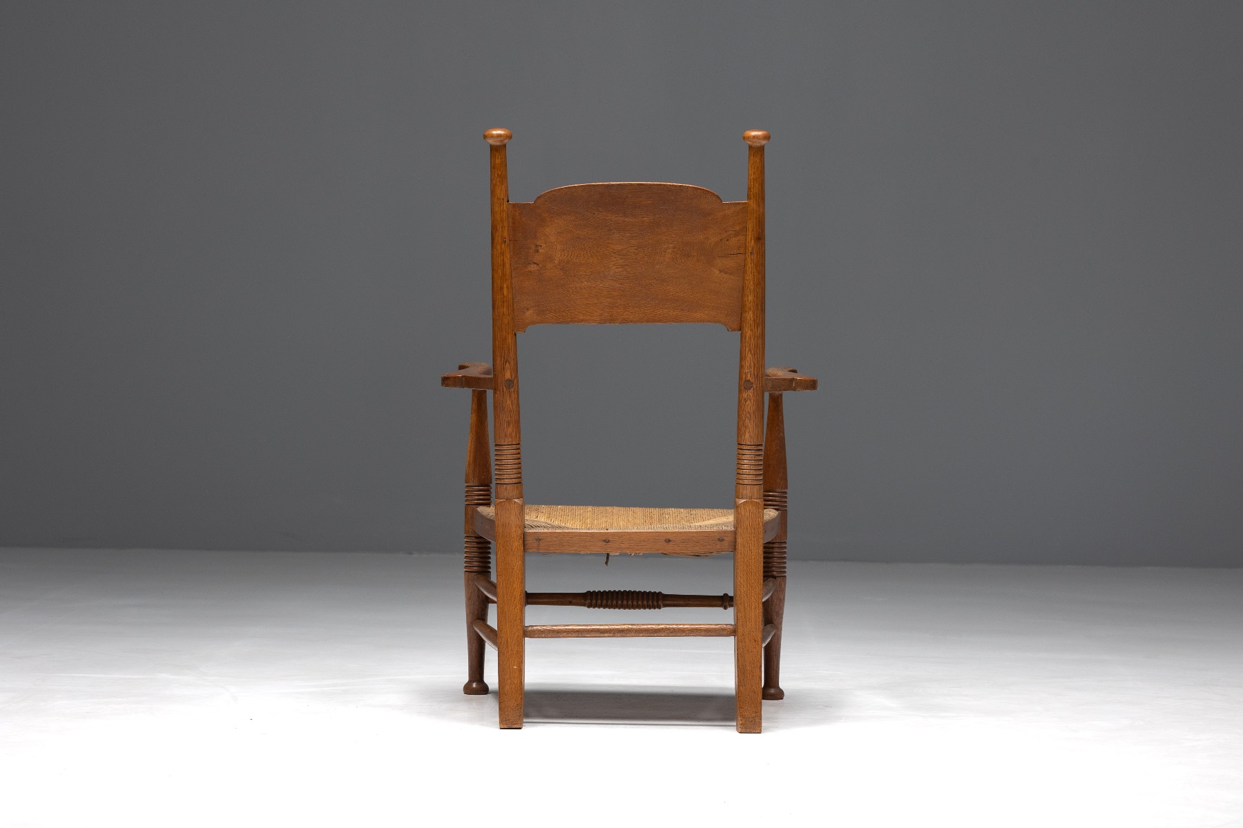 Traditional oak armchair with woven straw seat