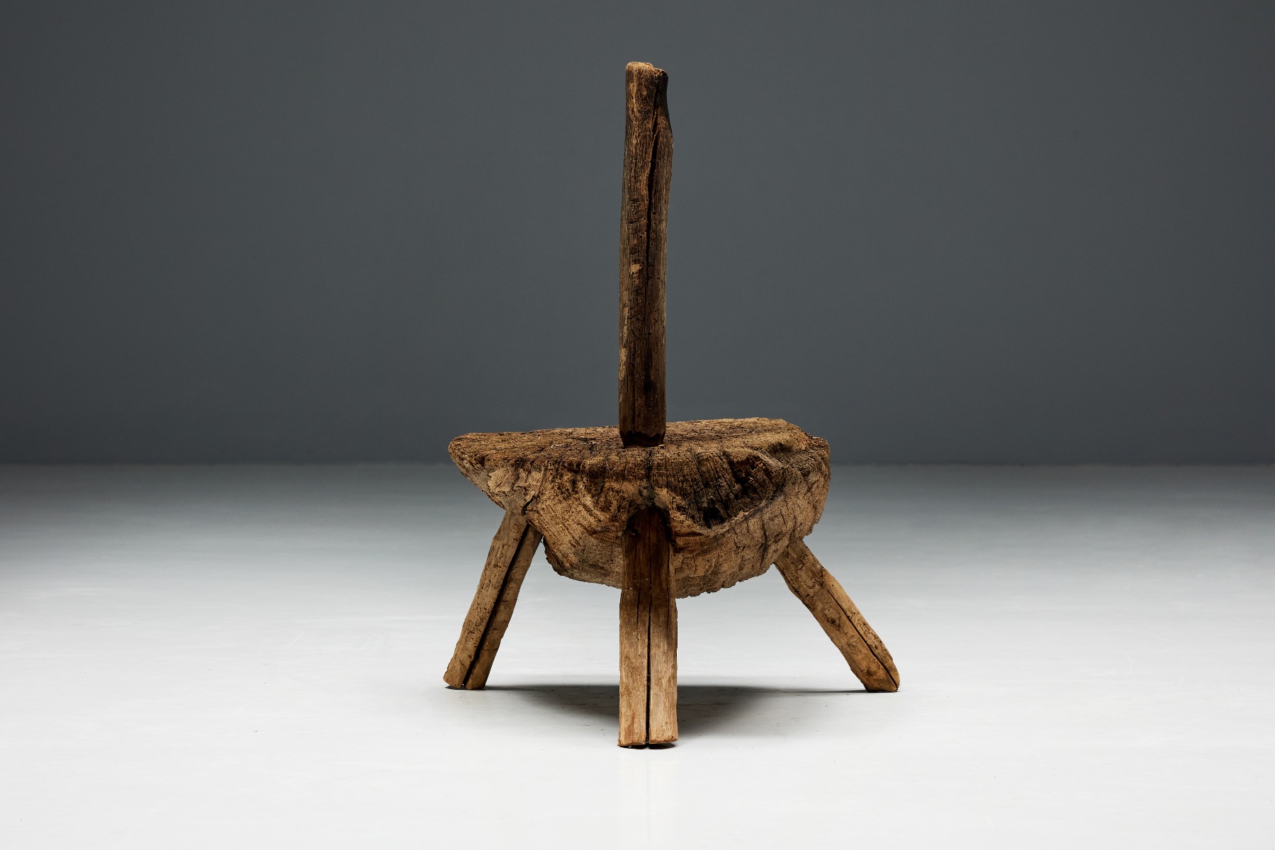 Antique rural monoxylite chair with tripod design