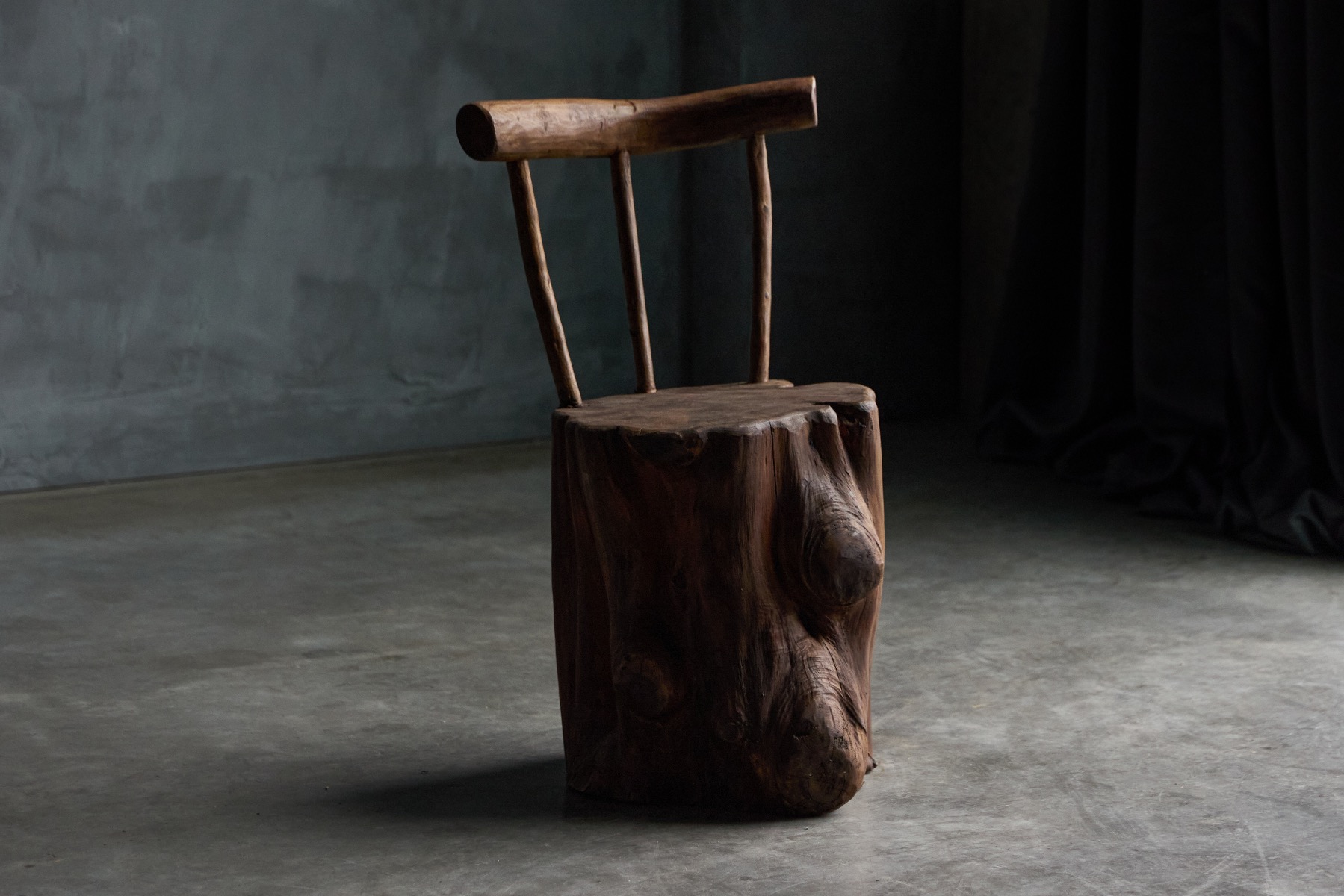 Rustic brutalist chair carved from a single block of wood